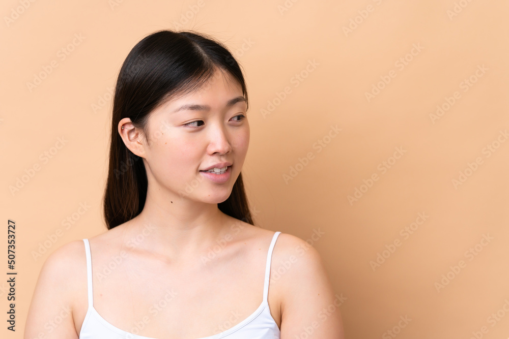 Young Chinese woman isolated on beige background . Portrait Young Chinese woman isolated on beige background . Portrait