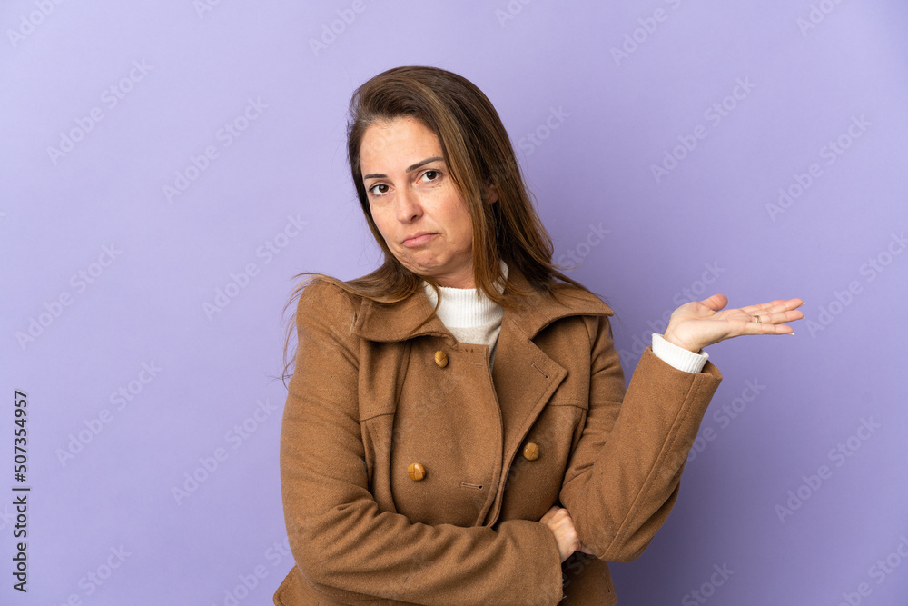 Middle age Brazilian woman isolated on purple background having doubts Middle age Brazilian woman isolated on purple background having doubts