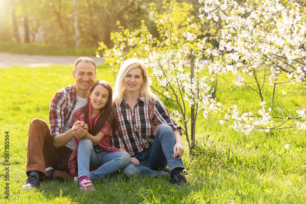 Happy family spending good time together in spring in a flowering garden Happy family spending good time together in spring in a flowering garden