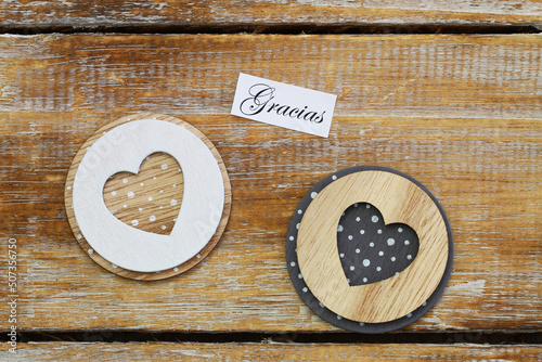 Obraz na płótnie Gracias (thank you in Spanish) card with two wooden hearts on rustic surface
w salonie