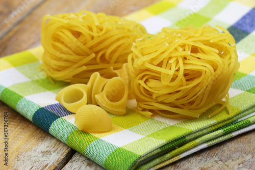 Uncooked Italian pasta on kitchen cloth closeup
