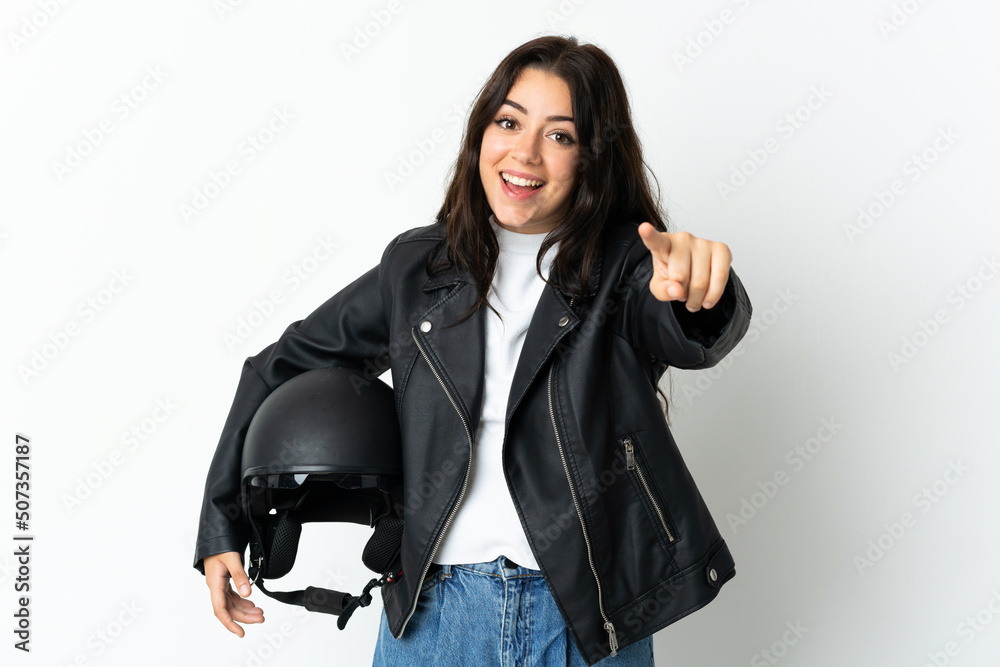 Woman holding a motorcycle helmet isolated on white background surprised and pointing front Woman holding a motorcycle helmet isolated on white background surprised and pointing front