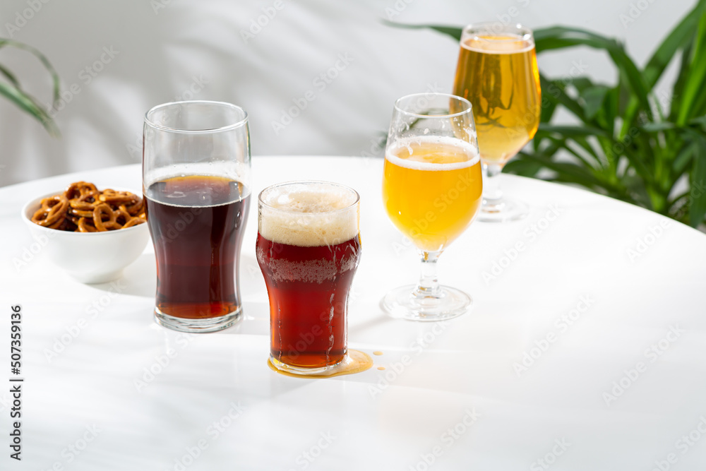 Several glasses with light and dark beer on light table copy space snack craft Several glasses with light and dark beer on light table copy space snack craft