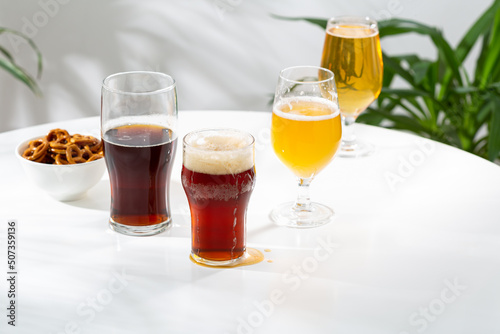 Several glasses  with light and dark beer on light table copy space snack craft