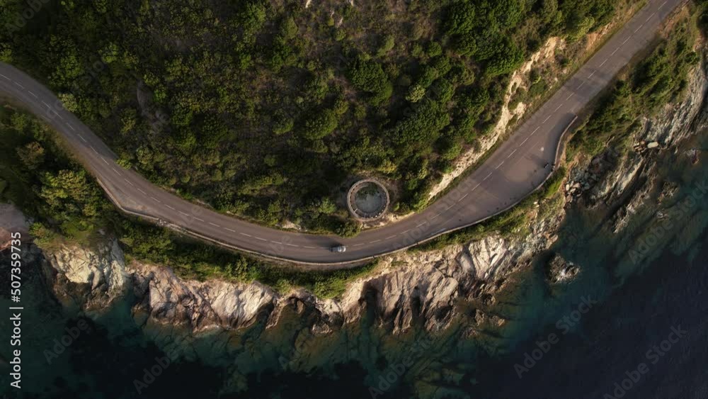 voiture sur une route sur le littoral du Cap Corse et une tour génoise au bord de la Méditerranée - Haute Corse