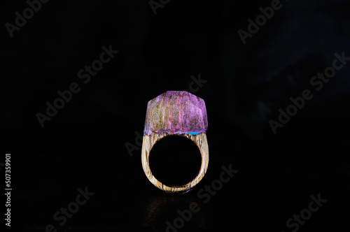  Photo of a wooden female ring on a white background. Epoxy resin is often used for decor and decorations. Eco-friendly material to create beautiful things. Bright unusual gift for a girl. 