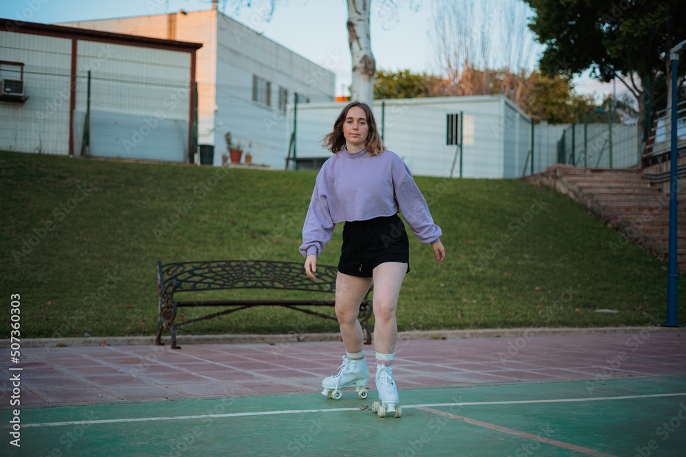 Obraz premium Teenage girl practicing rollerskating in the park.