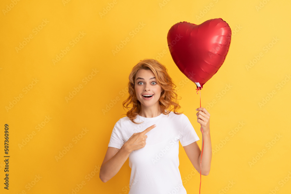 amazed redhead lady pointing finger on romantic gift of party balloon. happy valentines day amazed redhead lady pointing finger on romantic gift of party balloon. happy valentines day