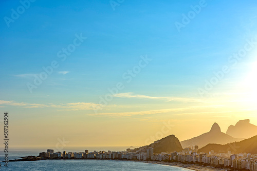 Copacabana Beach, its buildings and the mountains of Rio de Janeiro seen from above during the summer sunset