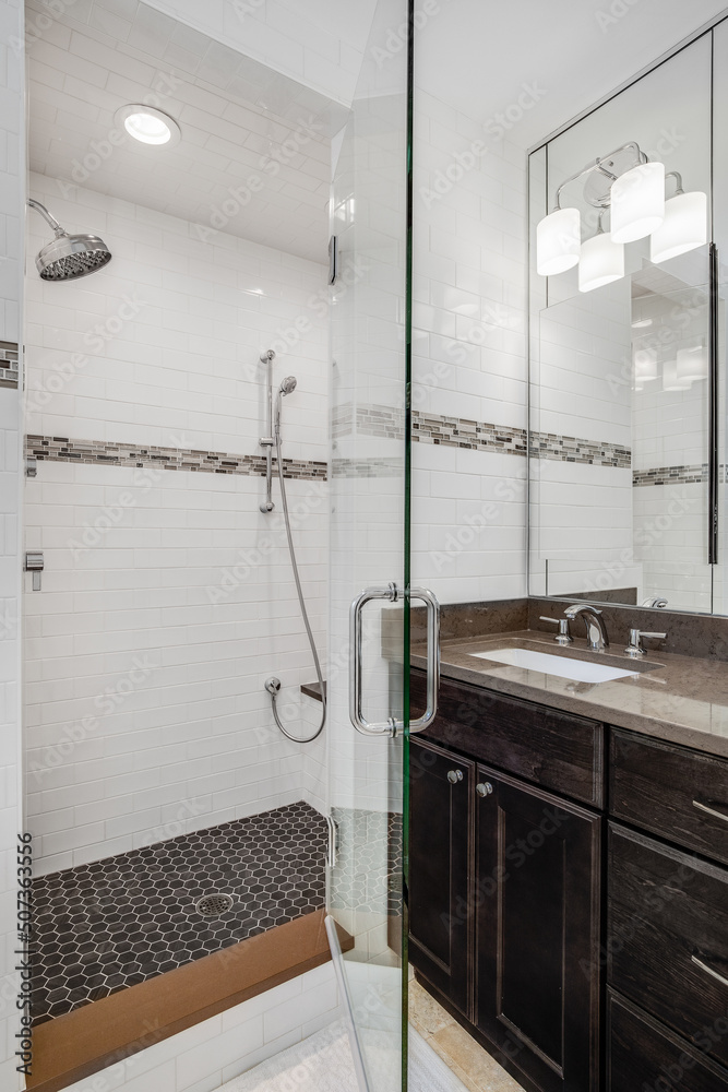 Looking into a bathroom with a wooden vanity cabinet, marble countertop ...