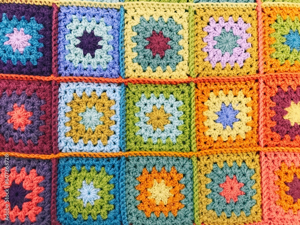 Handmade crocheted colourful blanket. Background and texture.