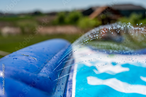 Selective focus on jets of droplets shooting out across a water slide