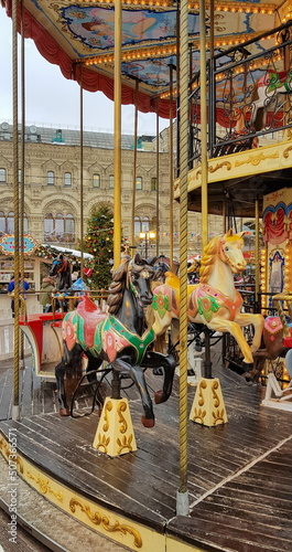 Carousel on the town square during the Christmas holidays. Wooden horses.