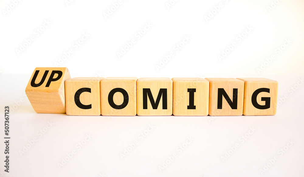Coming or upcoming symbol. Turned wooden cubes and changed the word Coming to Upcoming. Beautiful white table white background. Business coming or upcoming concept. Copy space. Coming or upcoming symbol. Turned wooden cubes and changed the word Coming to Upcoming. Beautiful white table white background. Business coming or upcoming concept. Copy space.