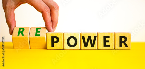 Power or repower symbol. Businessman turns wooden cubes and changes concept words Power to Repower. Beautiful yellow table white background. Business ecological power or repower concept. Copy space. photo