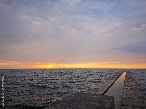 View of the Black Sea from the beach of Odessa  Ukraine . Calm sea  a seagull sits on a breakwater against the backdrop of dawn over the water. Tourist place  recreation area