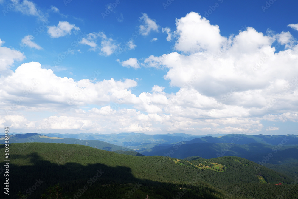 Beautiful view of majestic, green mountains and blue sky with clouds