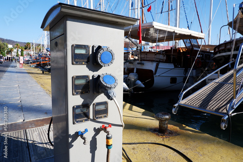 Electrical power sockets bollard on pier near sea coast. Charging station for boats in Mediterranean. Electrical outlets to charge ships in harbor.