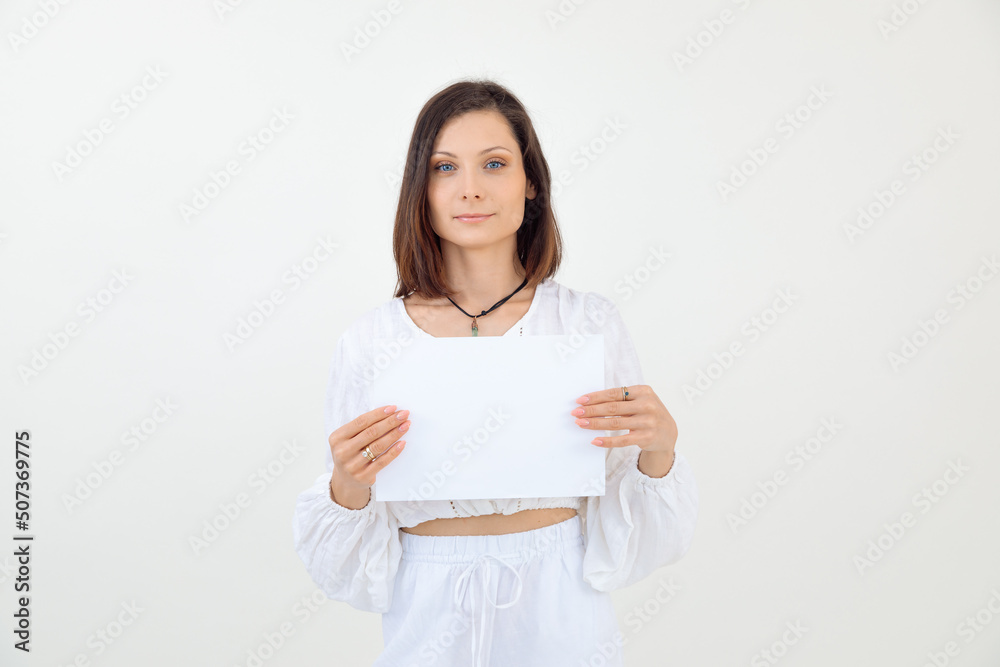 Charming smiling and confident brown-haired woman in white clothes with template promo, banner for text. Copy space Charming smiling and confident brown-haired woman in white clothes with template promo, banner for text. Copy space