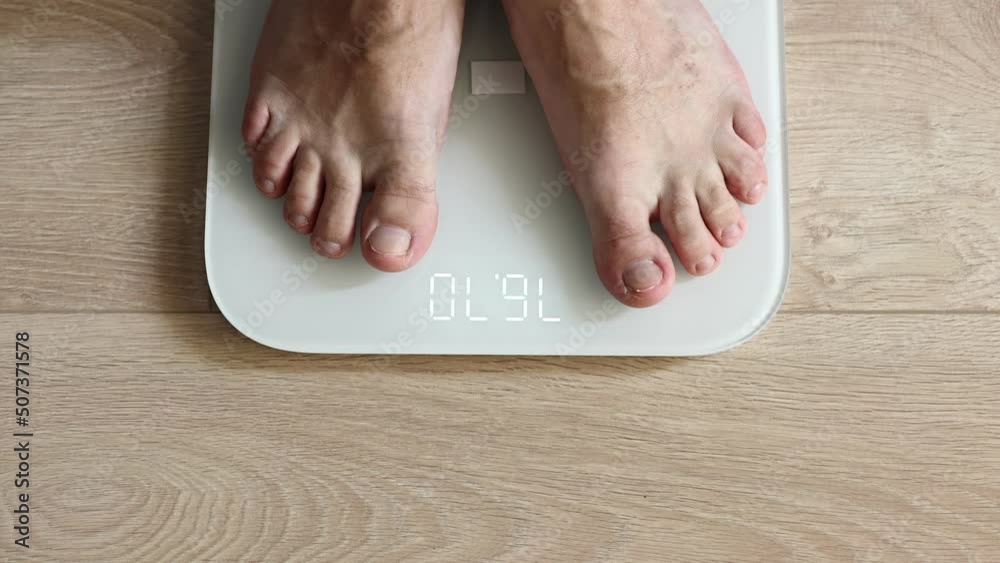 close up of Man walking on scales measure weight. male wal checking BMI weight loss. human