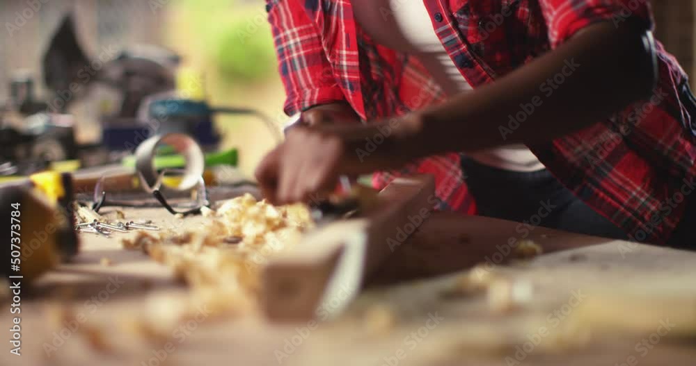 An African American female carpenter and joiner woodworker prepares timber for marking and cutting in her workshop, An African American female carpenter and joiner woodworker prepares timber for marking and cutting in her workshop,