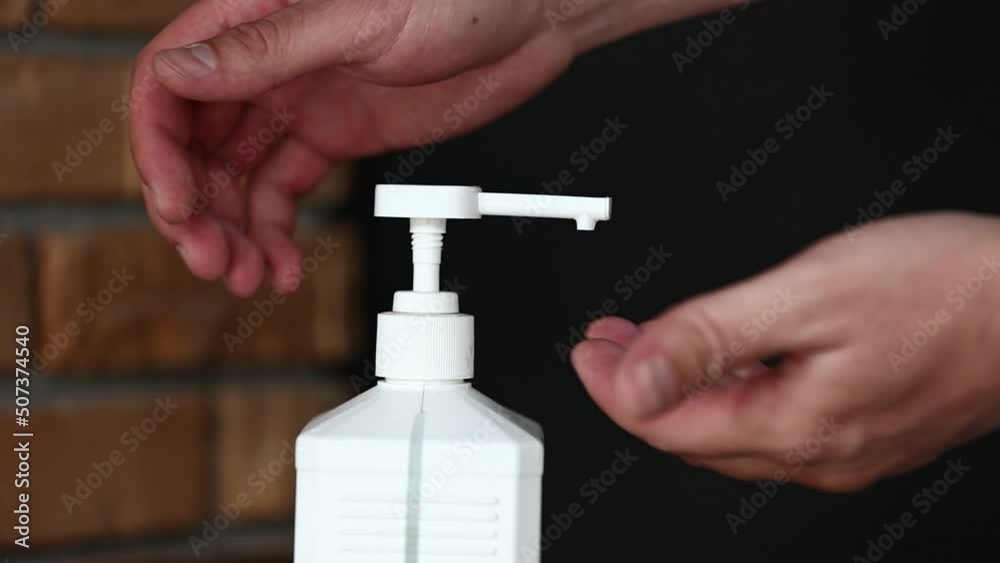 Closeup of man using hand sanitizer dispenser disinfecting with gel. used for hygiene and keeping hands clean to prevent virus spread, such as corona virus covid-19 or bacteria virus infection disease Closeup of man using hand sanitizer dispenser disinfecting with gel. used for hygiene and keeping hands clean to prevent virus spread, such as corona virus covid-19 or bacteria virus infection disease