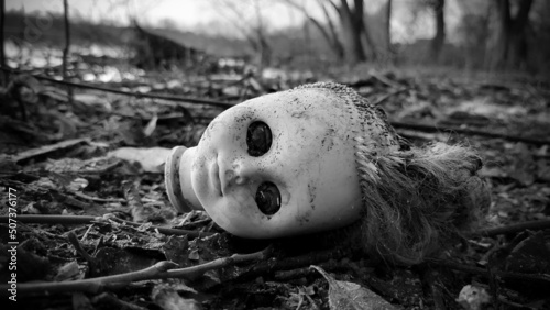 Foto The severed head of the doll lies in the mud on the river bank.
