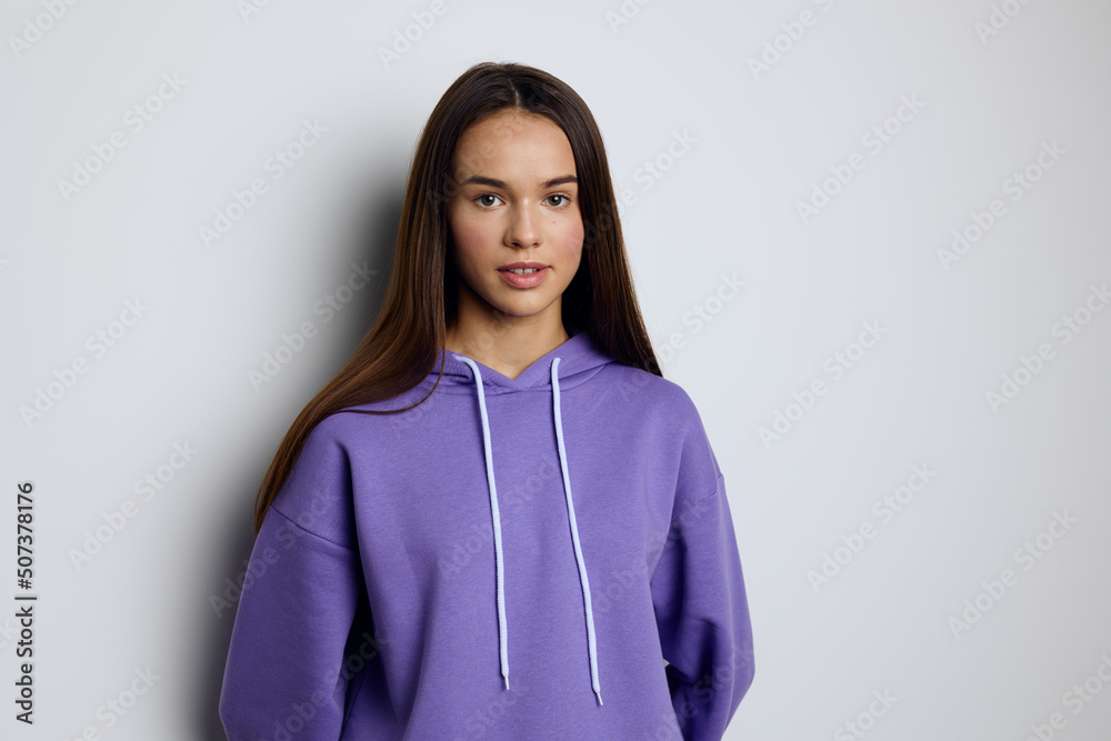 a calm, peaceful woman stands against a white background in a purple tracksuit with her hands down in a relaxed manner a calm, peaceful woman stands against a white background in a purple tracksuit with her hands down in a relaxed manner