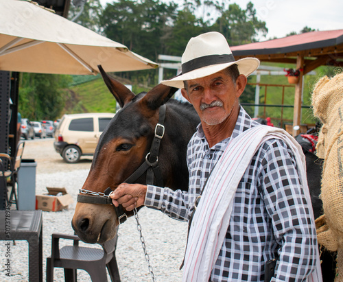 hombre, paisa, sonriendo,sosteniendo una mula  photo