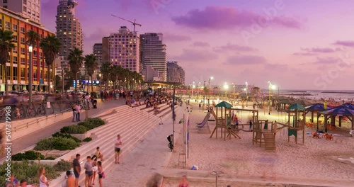 Night to day Time lapse of people traveling at tel aviv coastline Boardwalk and beach, next to the mediterranean sea, israel. zoom in effect photo