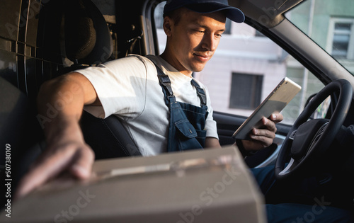 The driver in the uniform of the courier company fast delivery of goods to the house. © muse studio