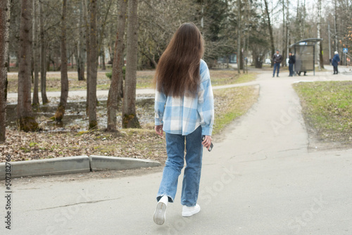Young girl walks through city. Student is outside in spring. Woman in Russia.
