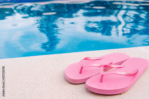 pink flip flops for swimming pool or beach. Swimming pool water texture. Pool background with summer objects. to use text.