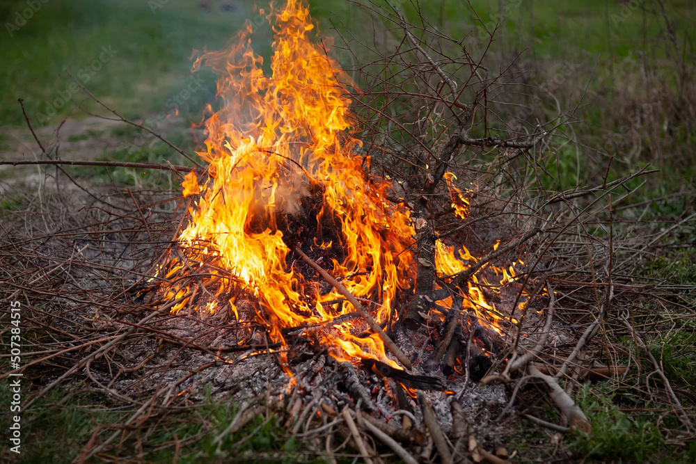 A peasant in the village made a fire from brushwood, evening of a spring day. A peasant in the village made a fire from brushwood, evening of a spring day.