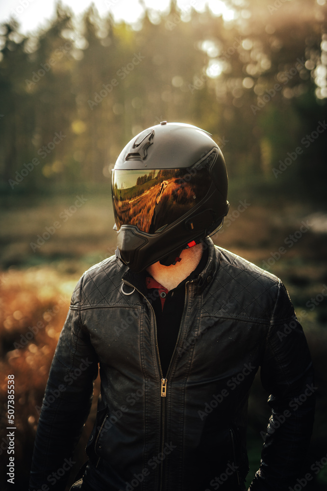 biker in helmet at sunrise with orange visor biker in helmet at sunrise with orange visor