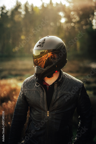 biker in helmet at sunrise with orange visor