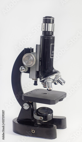 old analog microscope, mirror on white background with copy space