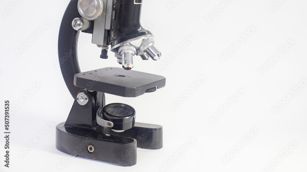 old analog microscope, mirror on white background with copy space