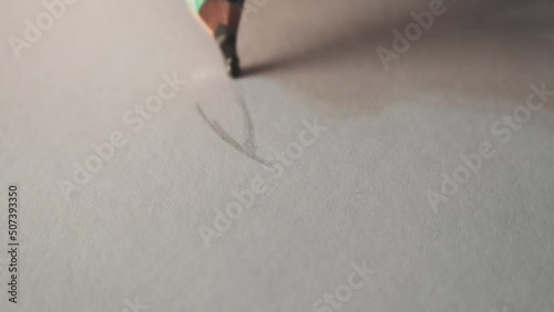 Close-up, adult hand drawing an eye on a paper