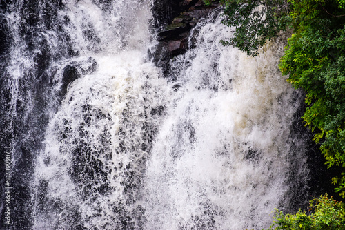 High speed waterfall with water colliding with trees and rocks. A Beautiful spectacle to watch 