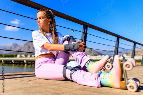 Protective skate safety concept , woman with equipment in beach and mountain background on a summer day photo