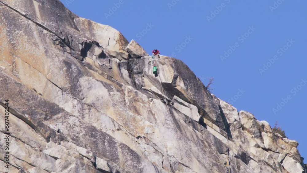 Epic timelapse of alpinist climbing top of high El Capitan Mountain summit peak in Yosemite National Park. Time Lapse RED footage of extremal rock climber pulling gear on top of El Capitan mountain 6K