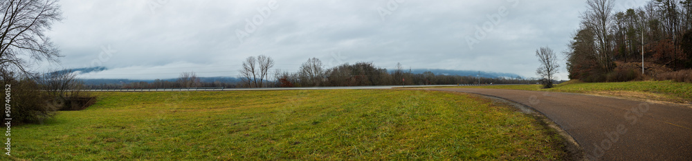 Grass field with road and overcast sky