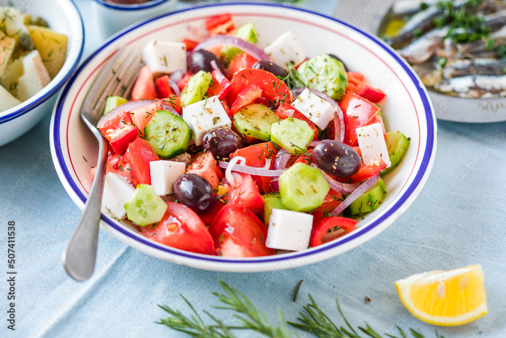 Greek salad with feta cheese, olives, cherry tomato, paprika, cucumber and red onion, healthy vegeterian mediterranean diet food, low calories eating. White stone background, top view
