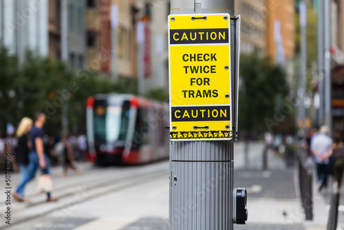 A warning sign advising pedestrians to watch out for trams on the shared road. George Street, Sydney,  Australia.