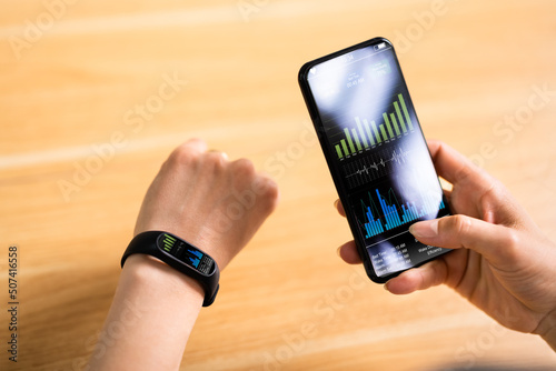 Woman With Smartwatch And Cellphone Monitoring Heart Rate photo