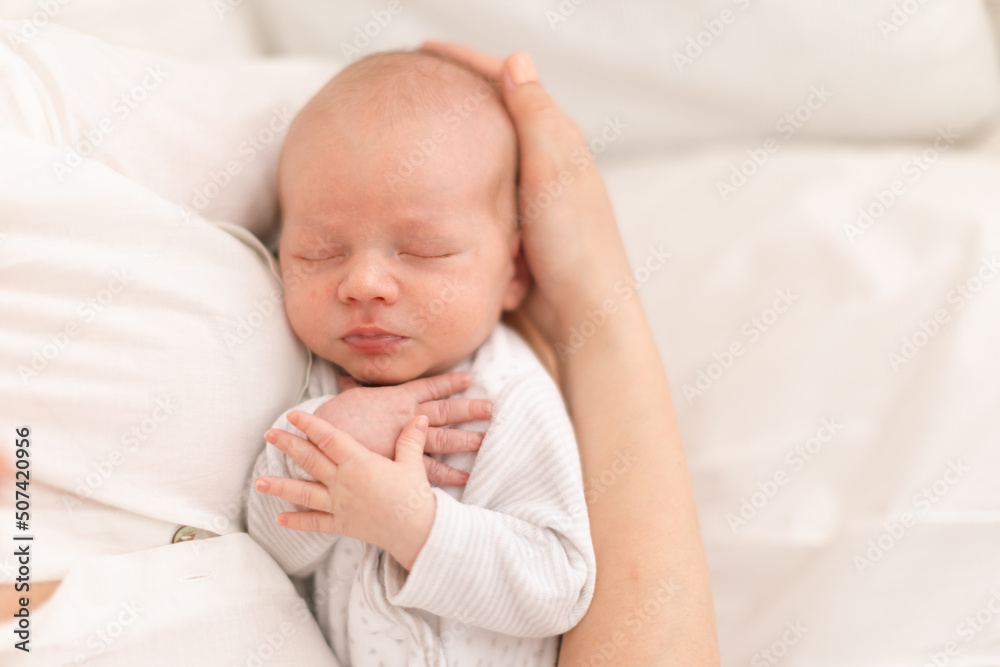 Unrecognizable mother holding her newborn son at home, close-up Unrecognizable mother holding her newborn son at home, close-up