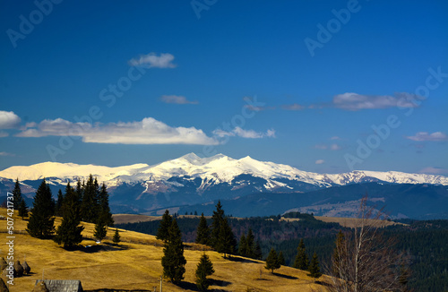 Landscape from the Tihuta pass - Romania with the top of the snow-capped mountains photo