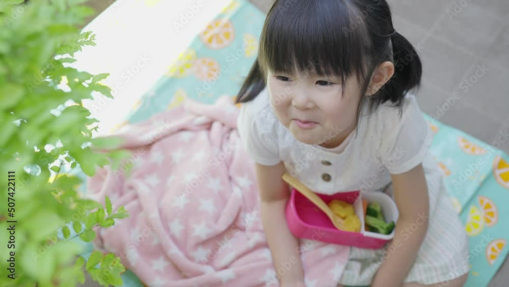 外でお弁当を食べる4歳の子供（ピクニック・レジャー・育児・子育て）