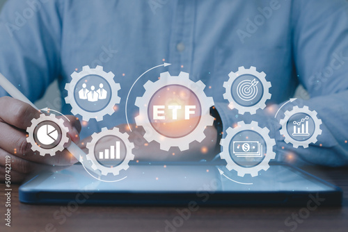 Person working on taplet to ETF Exchange traded fund stock market trading investment financial concept..